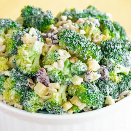 A white serving bowl of Healthy Apple Broccoli Salad with Walnuts and Cheddar