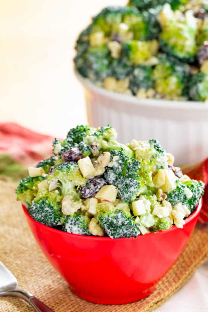 A small red bowl of Apple Walnut Broccoli Salad with Greek Yogurt