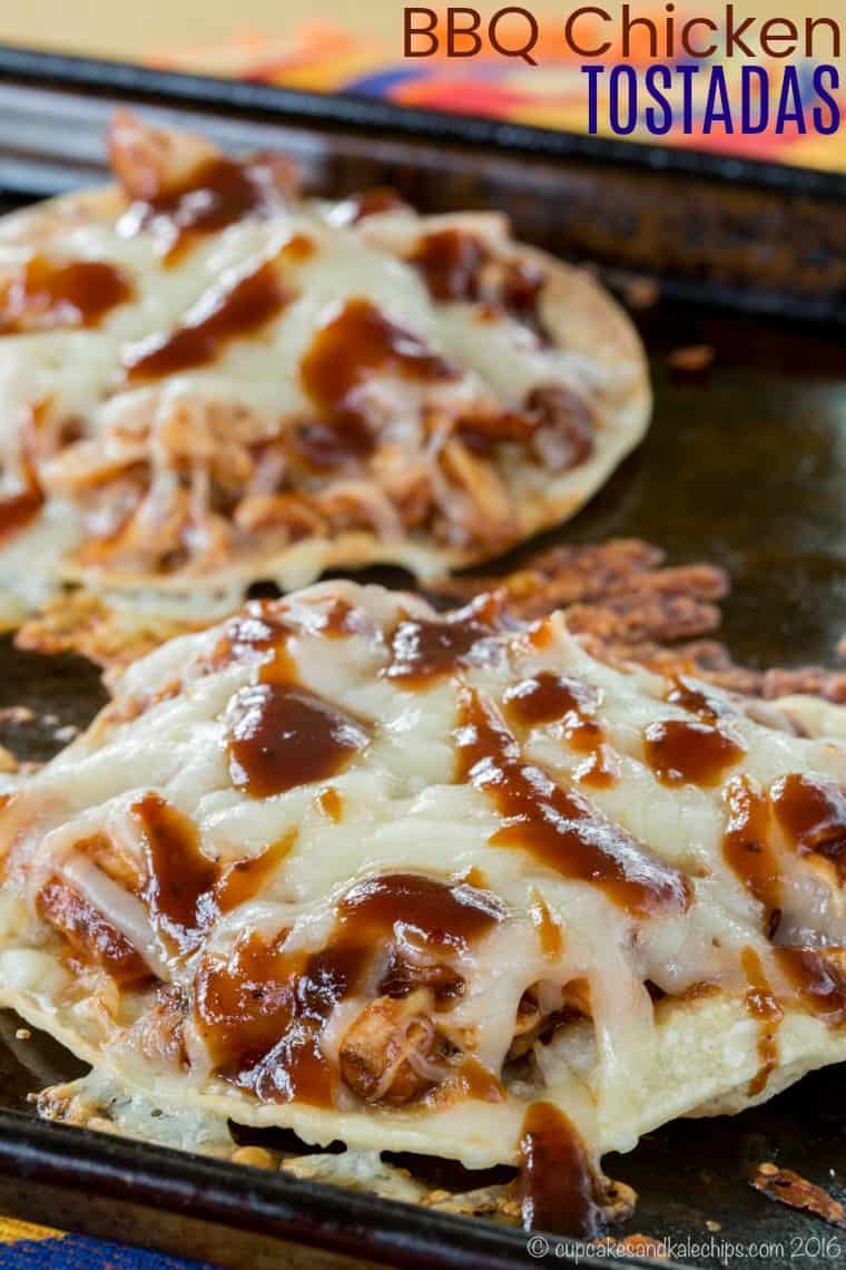 Barbecue Chicken Tostadas drizzled with BBQ sauce on a baking sheet