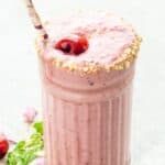 A light pink Smoothie in a glass with text overlay that says "Creamy Cherry Smoothie".