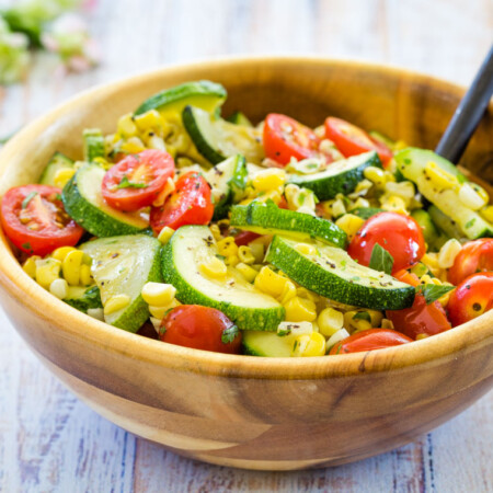 A wooden serving bowl with Sauteed Zucchini, Squash, Tomatoes, and Corn in Brown Butter