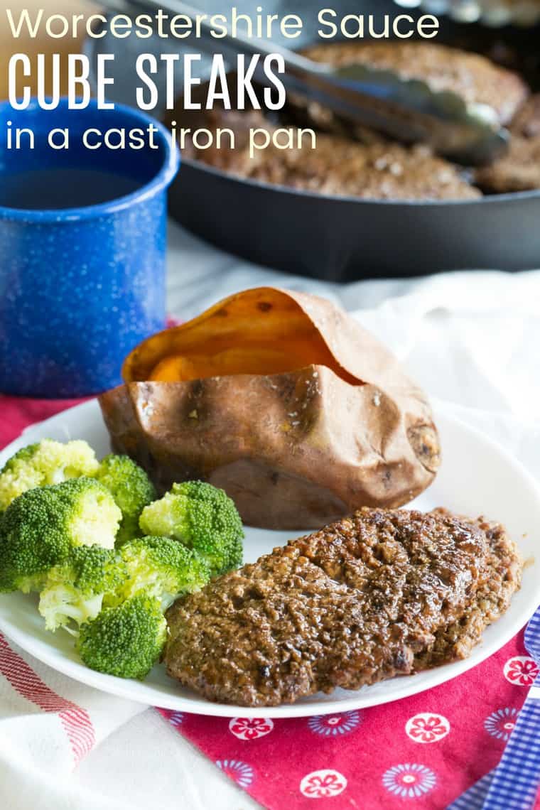 Cooked cube steak on a plate with a sweet potato and broccoli