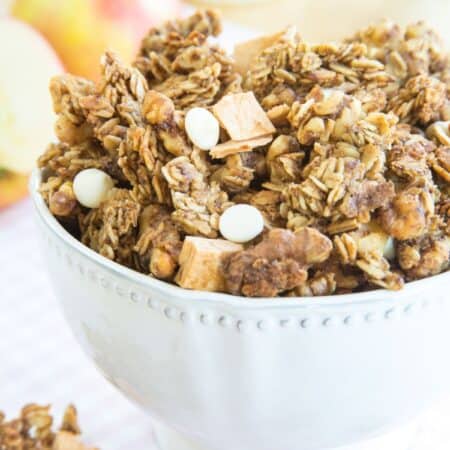 A white bowl of granola with text overlay that says "Cinnamon Apple Granola".