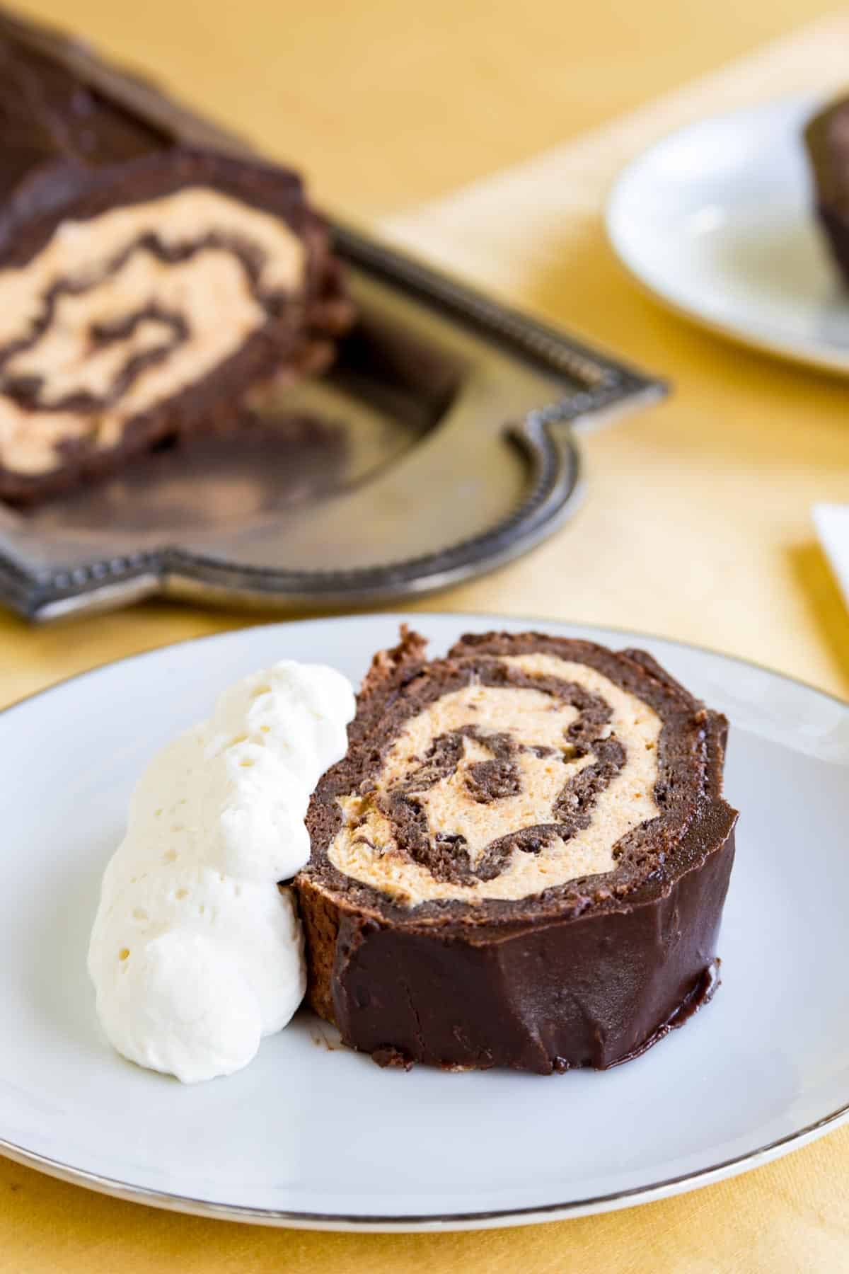 A slice of chocolate cake roll with pumpkin mousse
