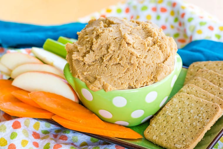 Peanut Butter Cookie Dough Dip in a green bowl on a platter with snacks