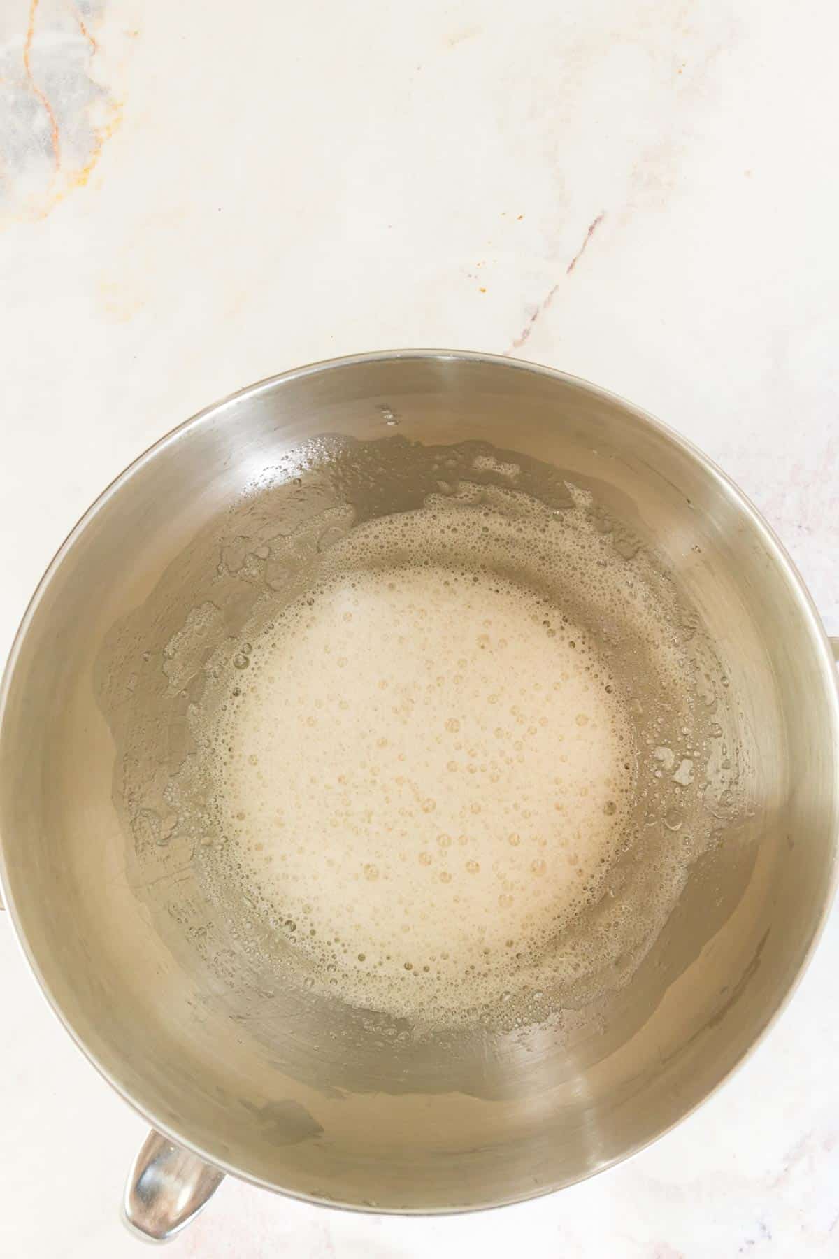 Whisked egg whites in a metal mixing bowl.