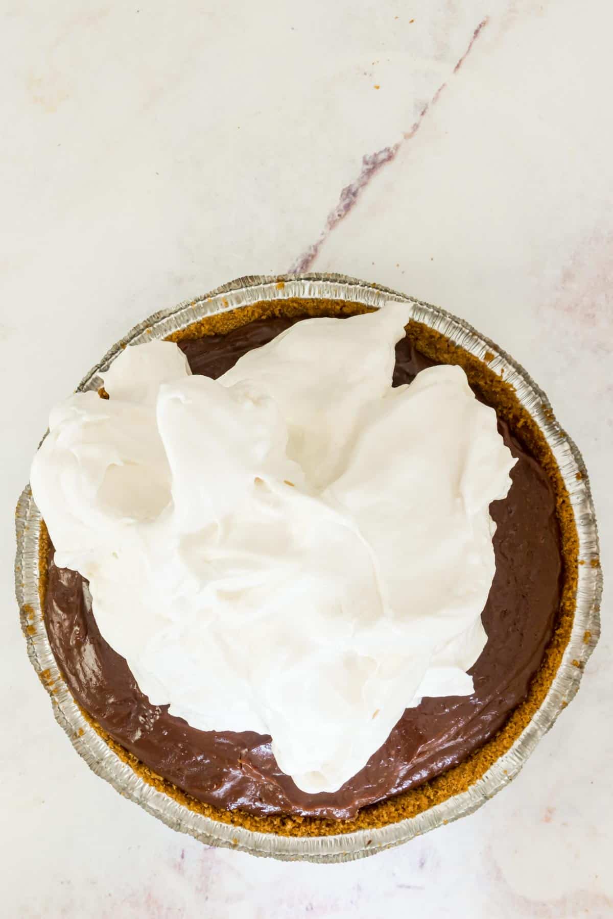 Marshmallow meringue added on top of chocolate pudding pie filling.