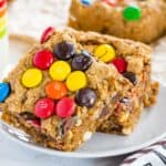 A stack of two No Flour Monster Cookie Bars on a small white plate
