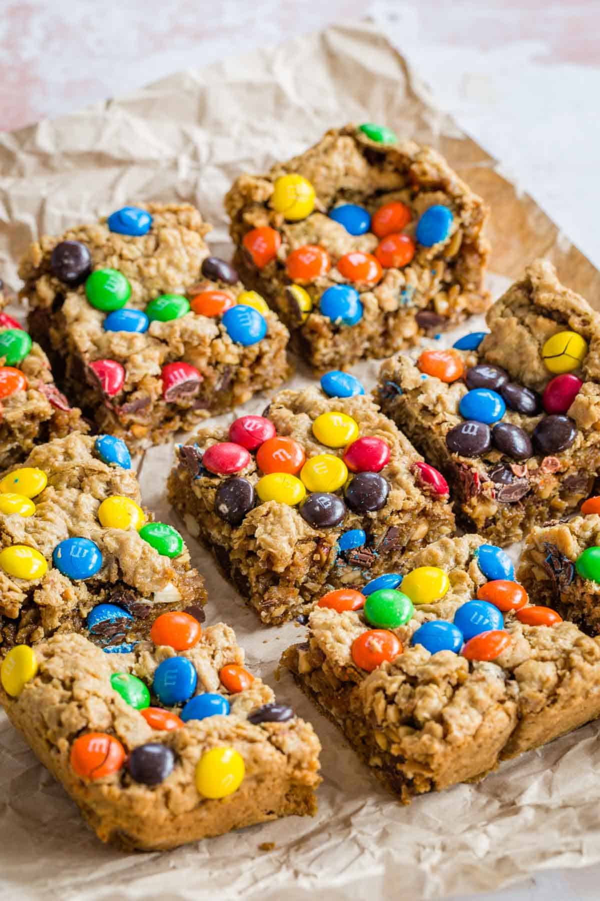 M&M's Monster Cookie Squares cut into bars on a wrinkly piece of parchment paper.