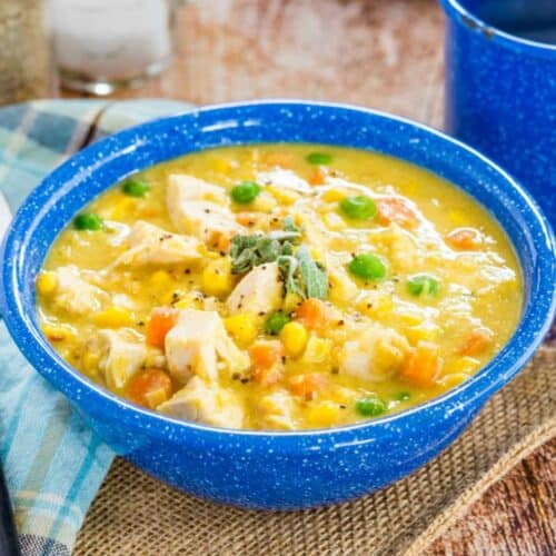 Chicken Corn Chowder in a blue speckled bowl with a garnish of pepper and minced sage.