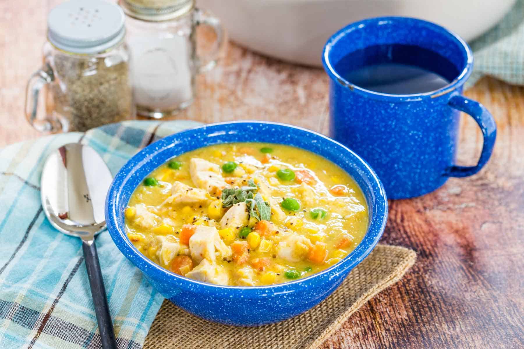 Bowl of Chicken Corn Chowder Soup and place setting on a table.