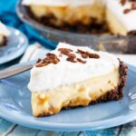Dulce de Leche Banana Cream Pie slice on a plate with whole pie in background