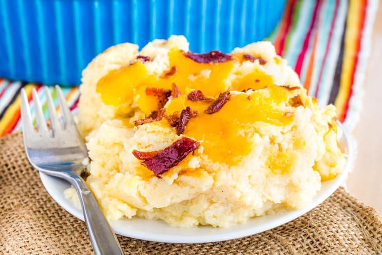 A scoop of Low Carb Cauliflower Mashed Potatoes with cheddar cheese and bacon on a plate