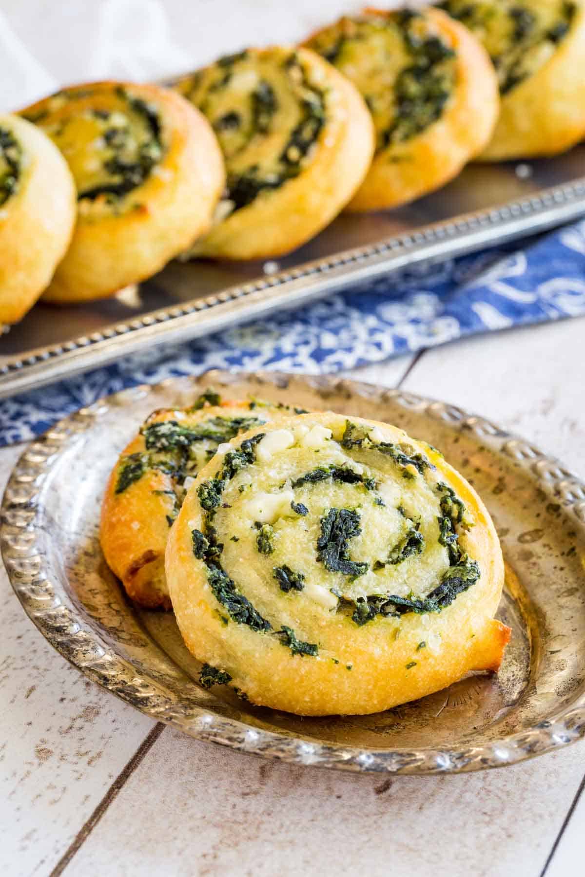 Small silver plate with two Spinach Feta Pinwheels on it.