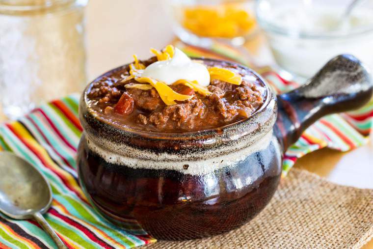 Instant Pot Keto Chili in a crock with cheese and sour cream on top