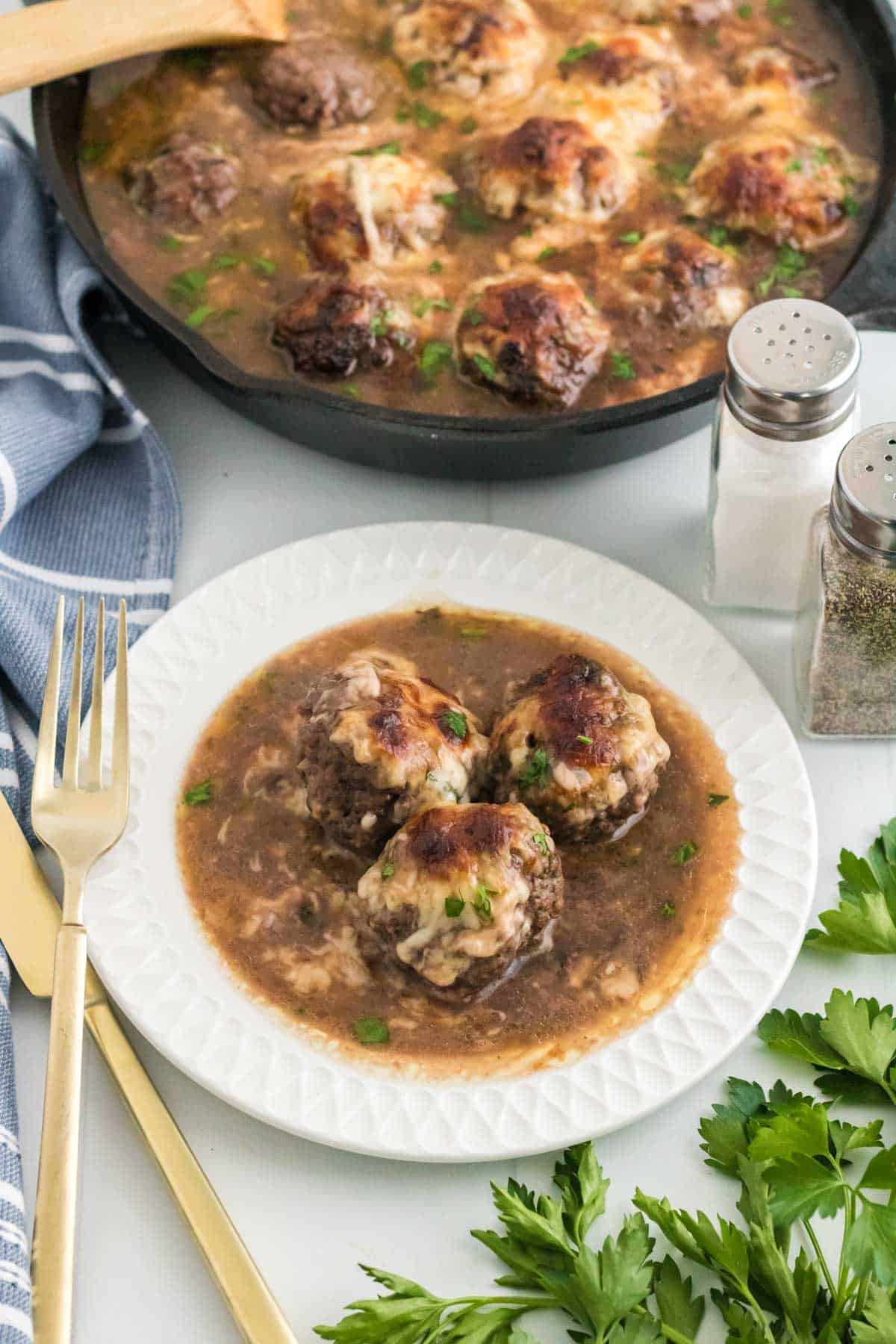 French onion meatballs in gravy on a plate.