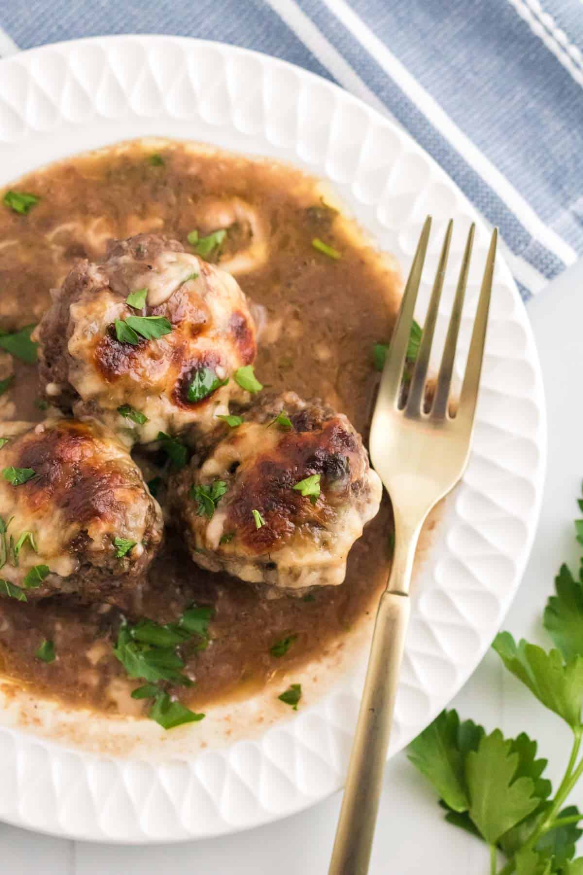 French onion meatballs in gravy on a plate.