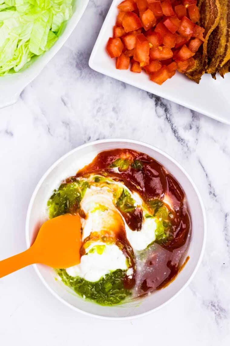 Combining the ingredients to make burger sauce.