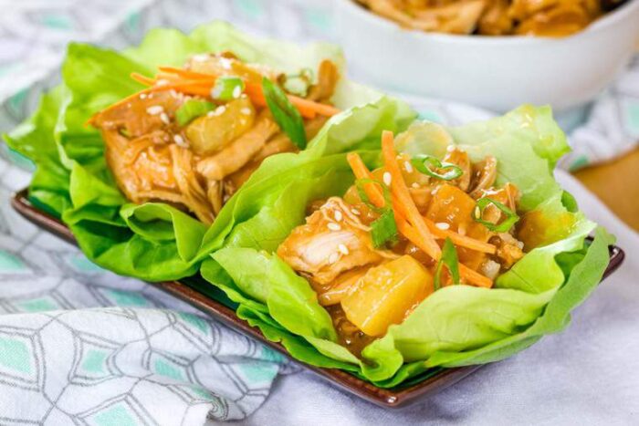 A small plate with teriyaki chicken lettuce wraps