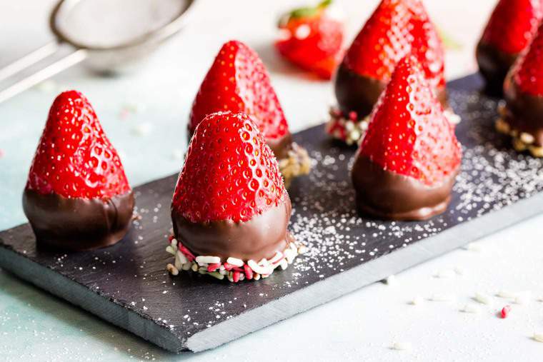 Chocolate Covered Cheesecake Strawberries with sprinkles and chopped pecans