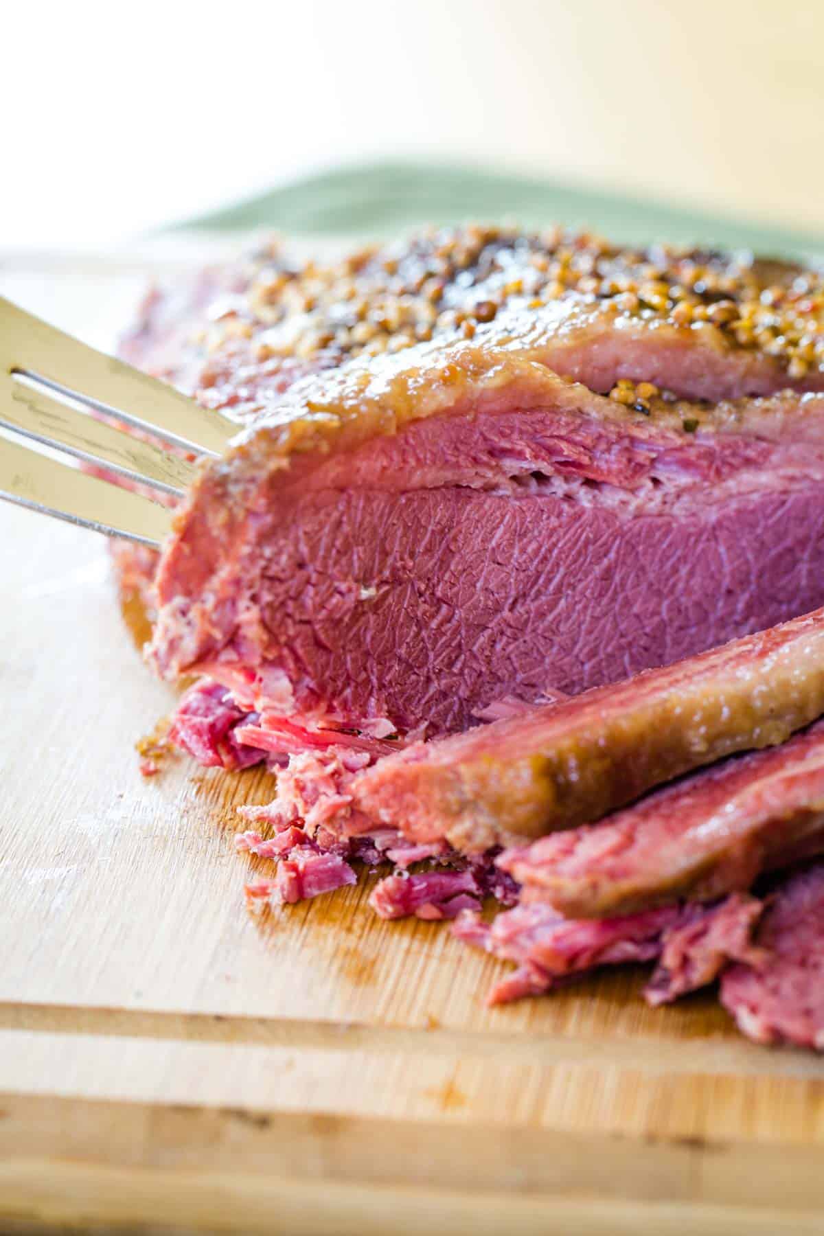 A slice of cooked beef brisket being speared with a fork.