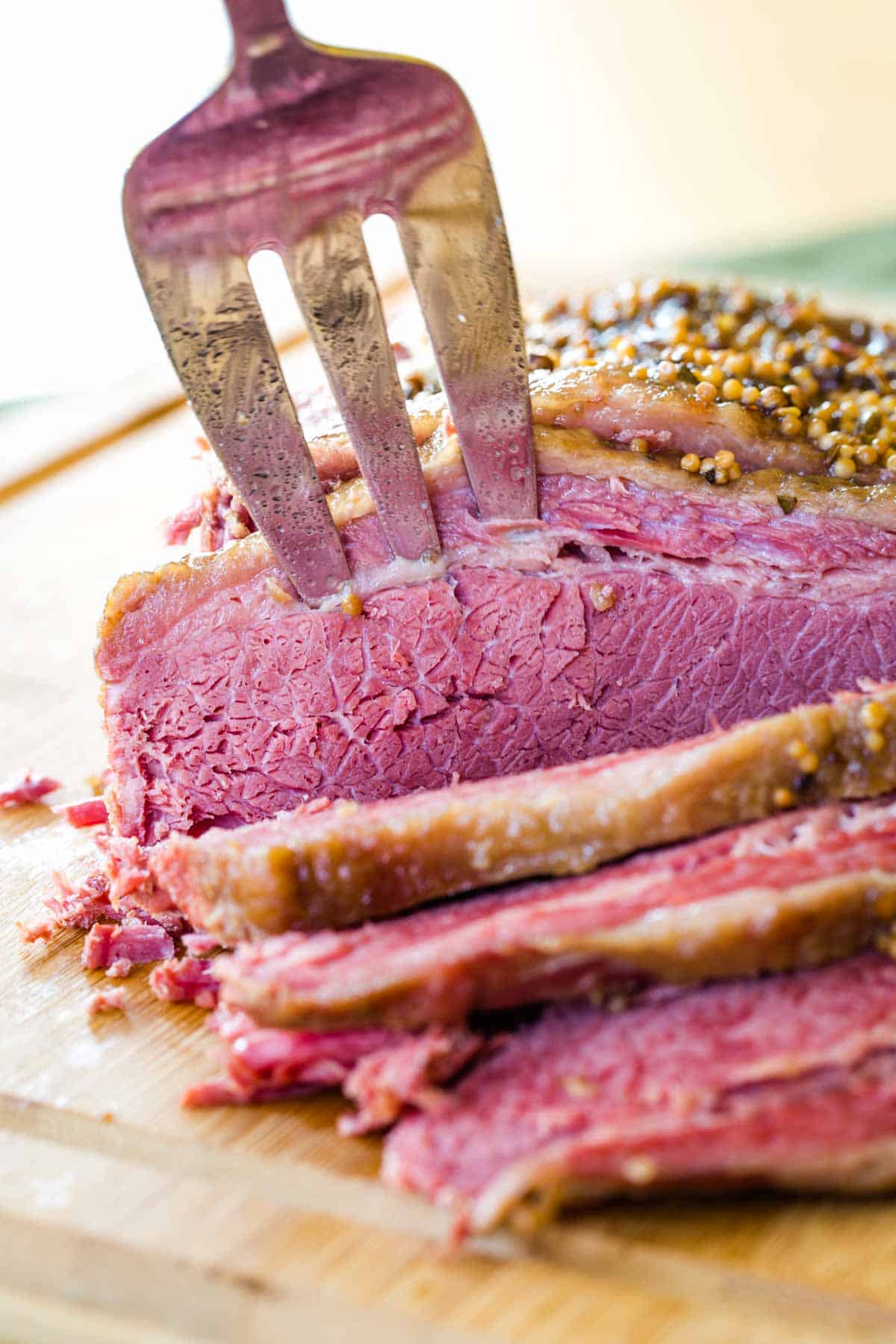 A slice of cooked beef brisket being speared with a fork.