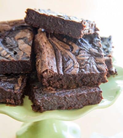Bailey's fudge brownies piled up on a small green cake stand.