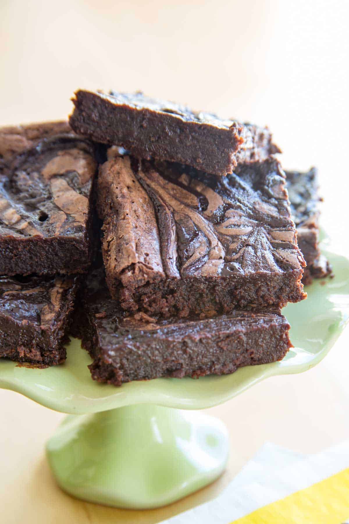 Bailey's fudge brownies piled up on a small green cake stand.