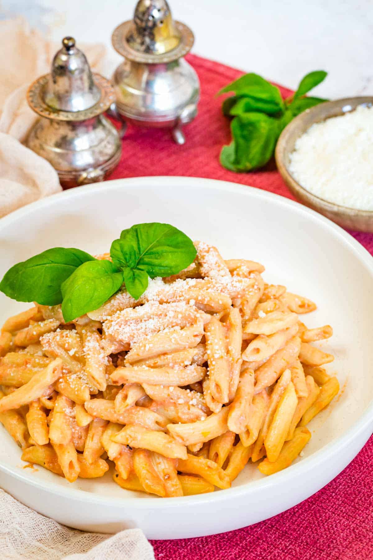 A white bowl filled with pasta in vodka sauce