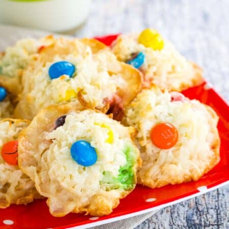 A pile of Coconut M&M's Macaroons on a red plate with white polka dots.