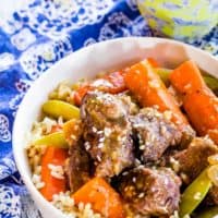 Crock Pot Mongolian Beef Stew with carrots and sugar snap peas in a bowl with rice