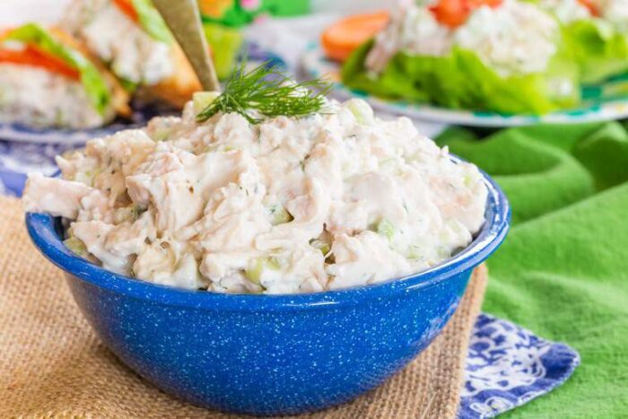 Tzatziki Chicken Salad in a bowl topped with a sprig of fresh dill