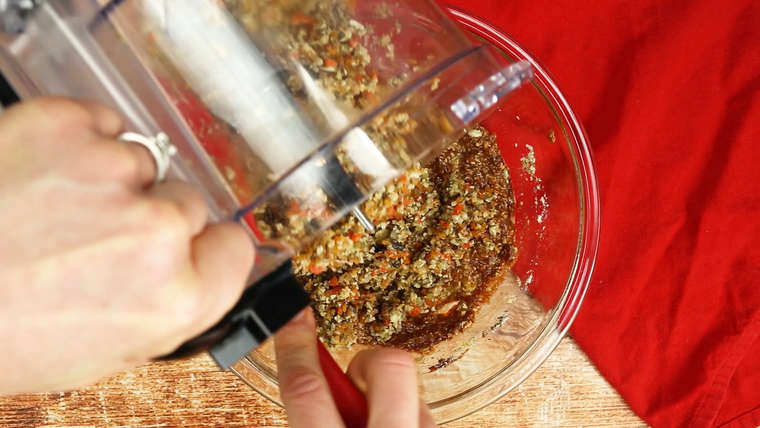 Adding roasted vegetable puree from food processor to bowl