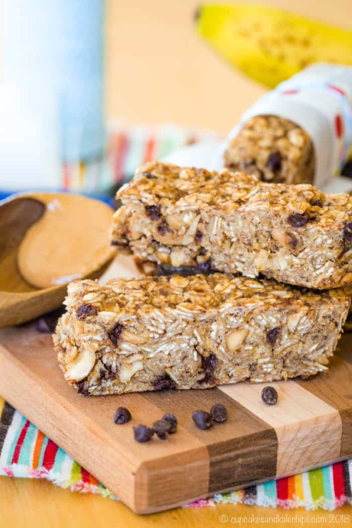 Banana Granola Bars with chocolate chips and a spoon of peanut butter on a cutting board