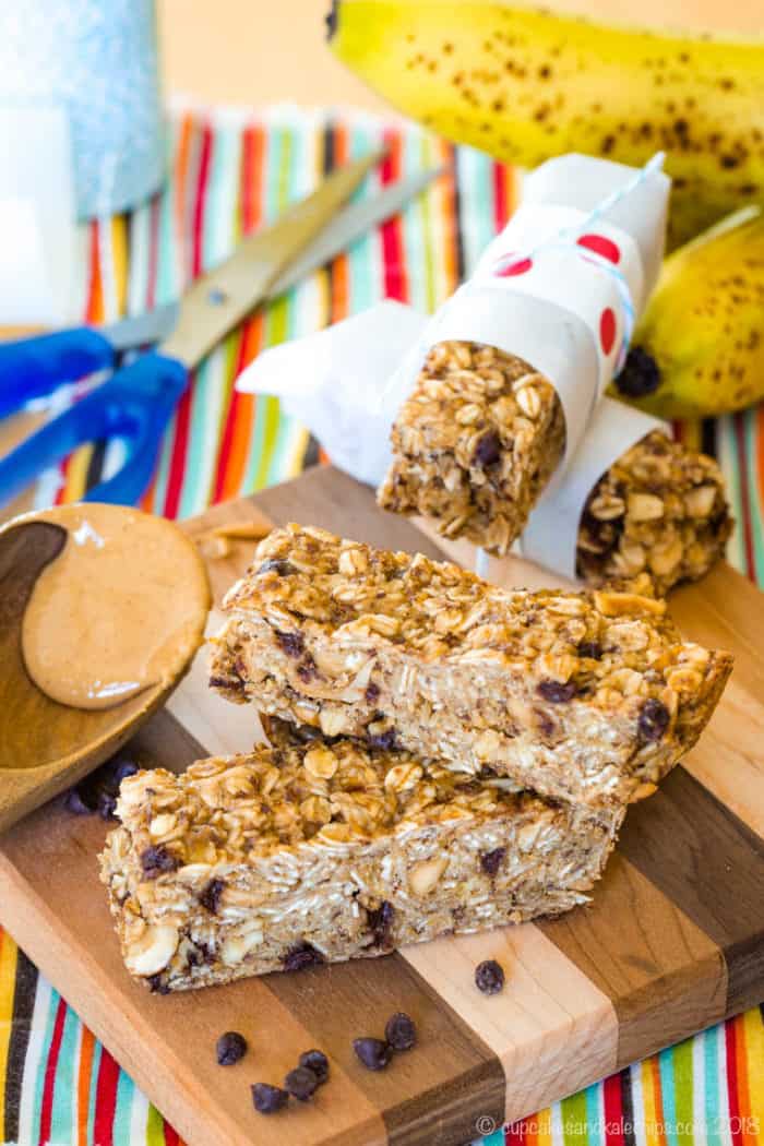 Overhead of Banana Peanut Butter Chocolate Chip Granola Bars with supplies for wrapping them in parchment paper