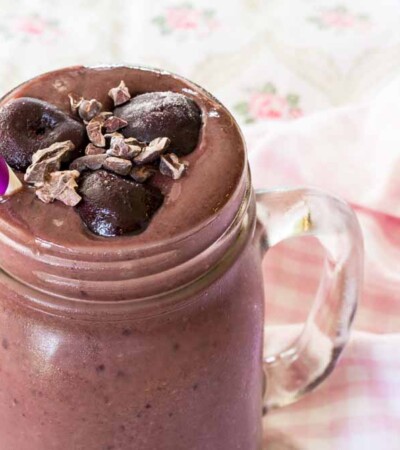 Black Forest Smoothie with cherries on top and a straw