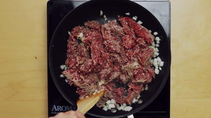 Brown ground beef with onions and garlic process shot