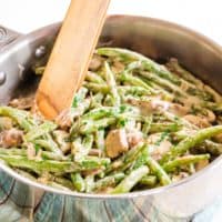 Creamy Skillet Green Beans and Mushrooms in a pan with tongs