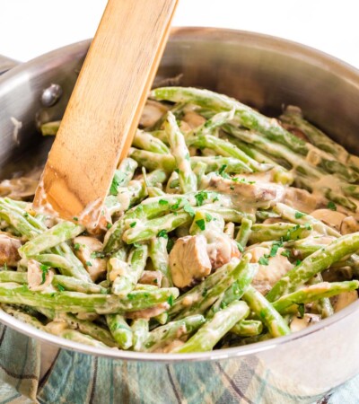 Creamy Skillet Green Beans and Mushrooms in a pan with tongs