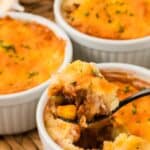 Three mini shepherd's pies, one with a spoon in it