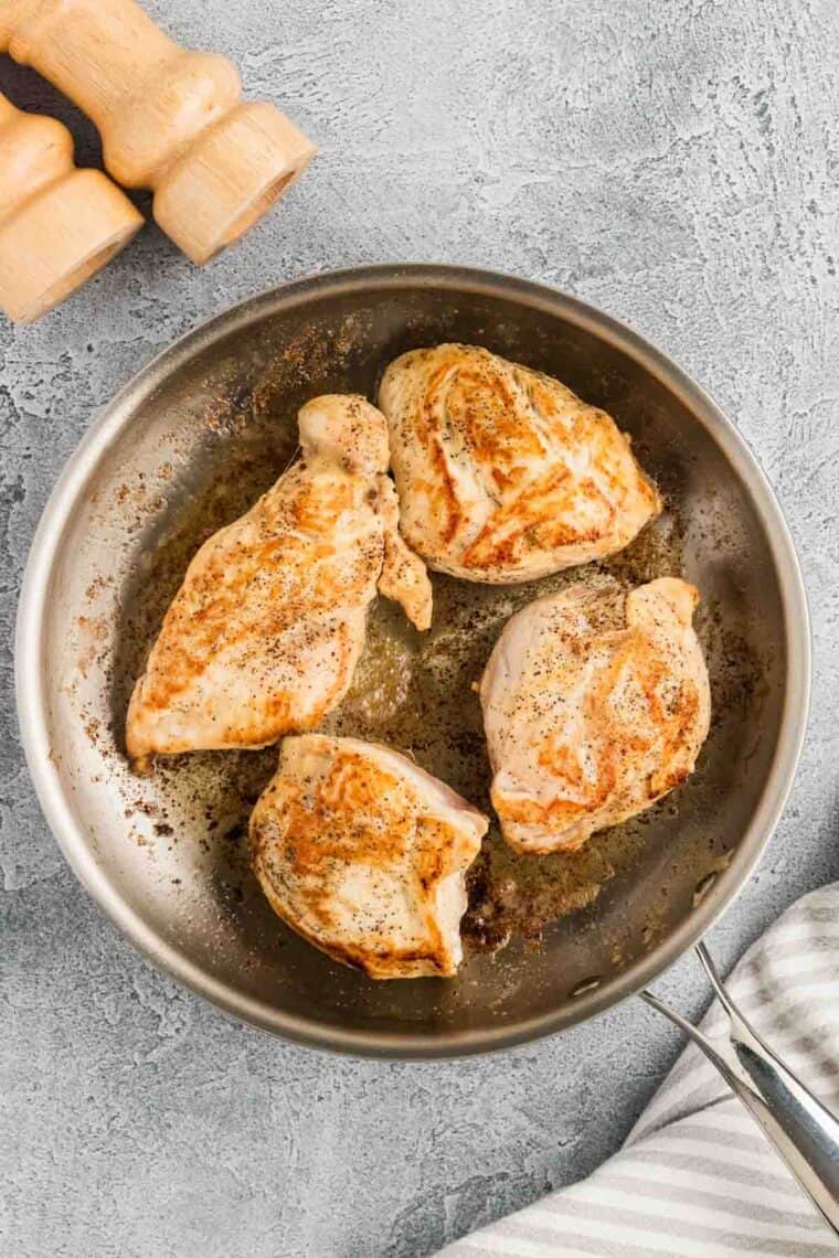 Browned pieces of chicken in a skillet