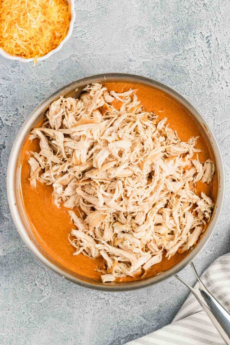 Shredded chicken returned to the pan with the enchilada sauce