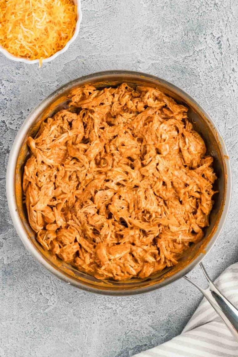 Shredded chicken coated with sauce in the pan