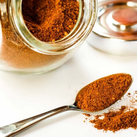A spoon spilling over with the spice mix of cinnamon, ginger, and cayenne pepper