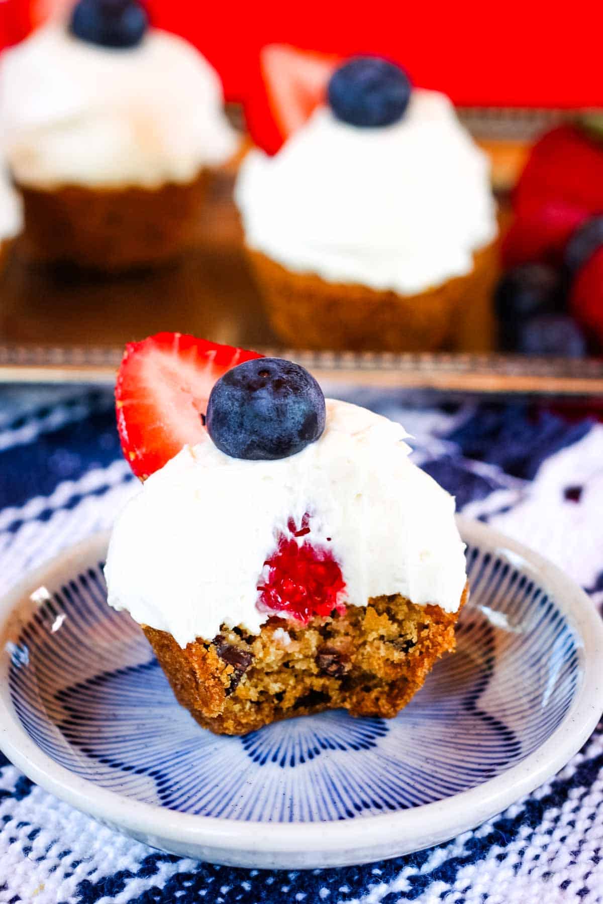 A berry cookie cup on a plate with a bite missing
