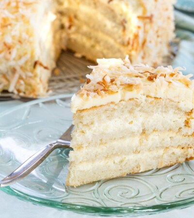 Gluten free white cake with coconut filling and frosting on a glass plate