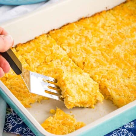 Serving Cauliflower Hash Browns Breakfast Bake from a rectangular pan with a spatula.