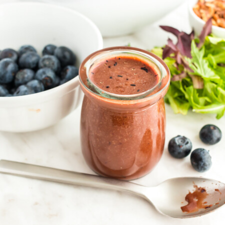 Balsamic Blueberry Vinaigrette in a small jar with a spoon in front