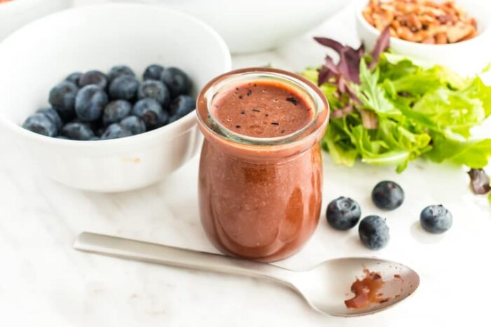 Balsamic Blueberry Vinaigrette in a small jar with a spoon in front