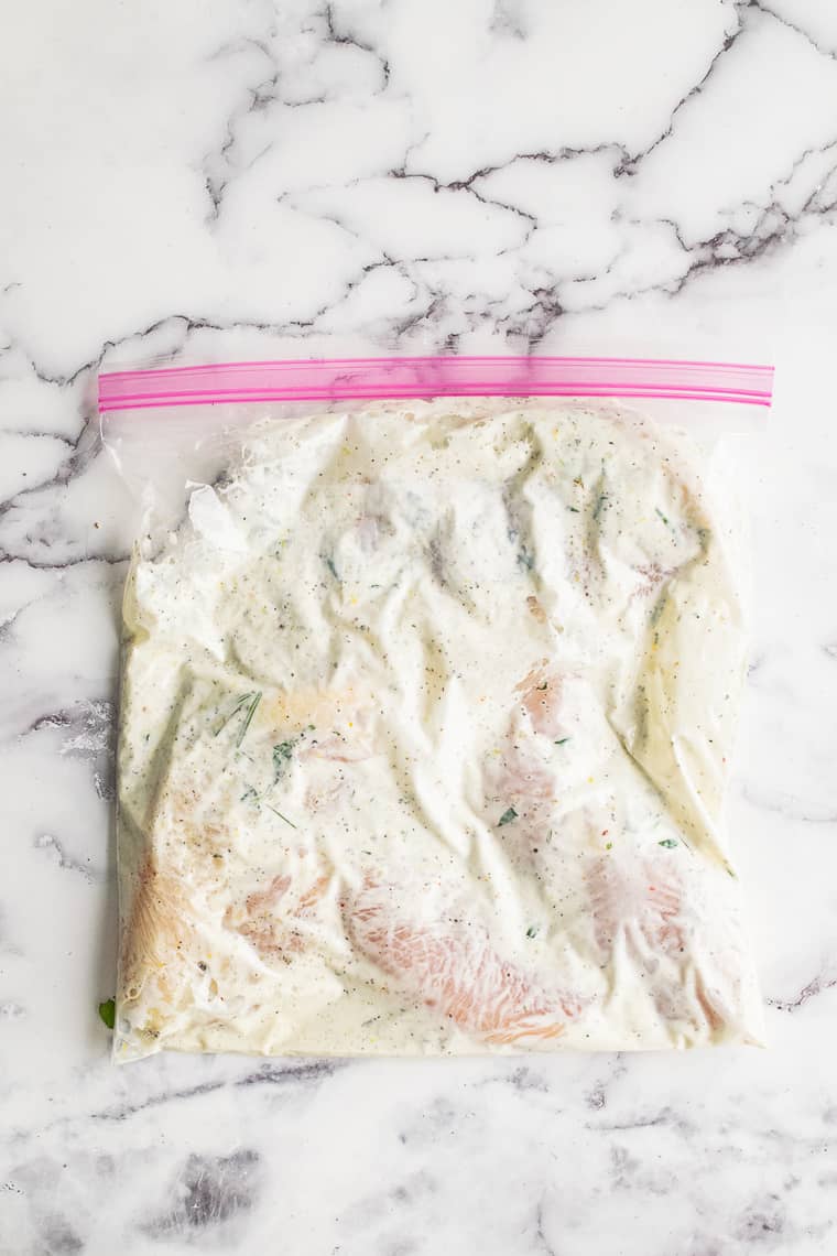 Chicken in lemon herb yogurt marinade in a ziploc bag